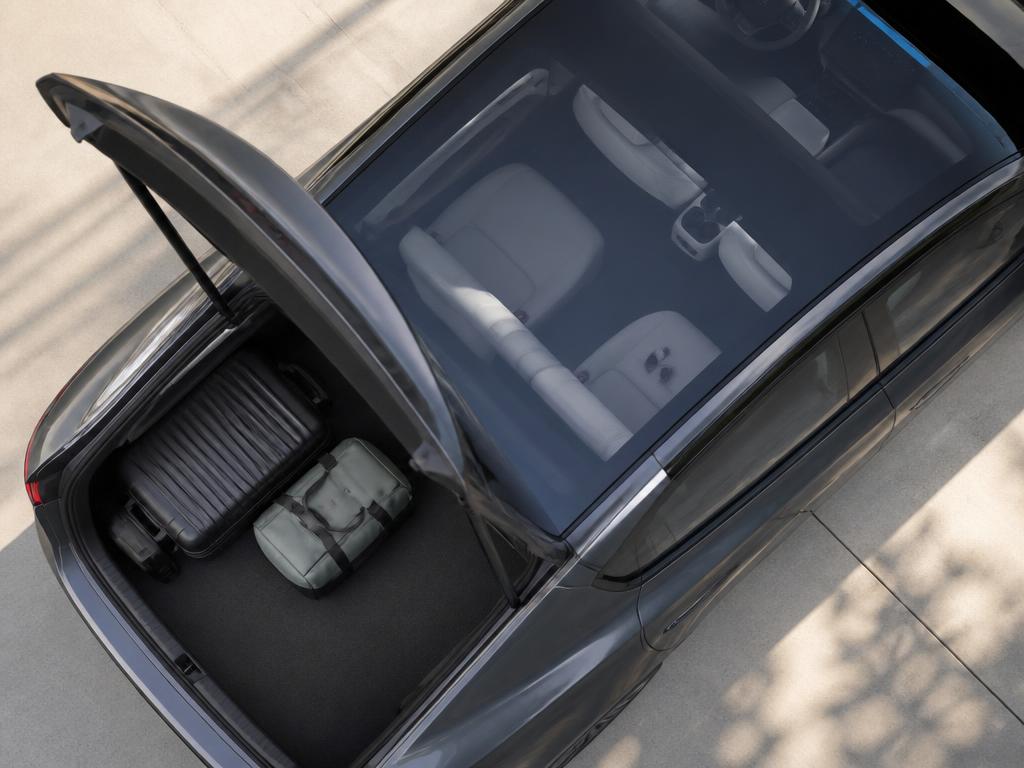 Otevřený kufr elektromobilu se zavazadly a klíči — doplňková pojištění